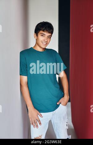 Young smiling handsome man posing on studio background looking to camera Stock Photo