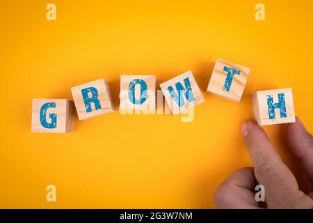 Growth concept. Six wooden cubes with text on a yellow background. Stock Photo