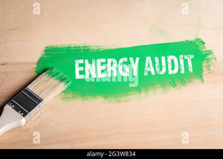 Energy Audit concept. Green color and a brush on a plywood background. Stock Photo