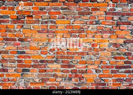 Old, rustic red corroded and damaged brick wall Stock Photo