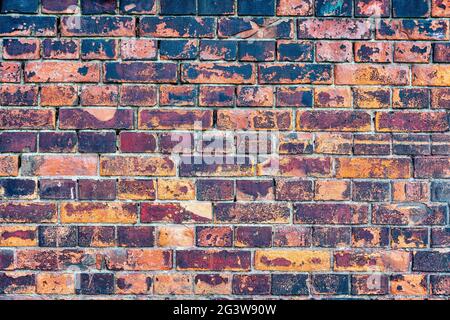 Old, rustic red corroded and damaged brick wall Stock Photo