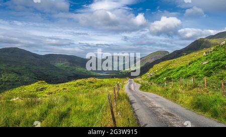 Country road leading to majestic Black Valley with lake and mountain range Stock Photo
