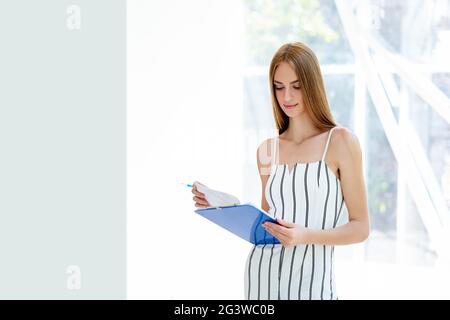 Pretty businesswoman reading documents in her modern office Stock Photo