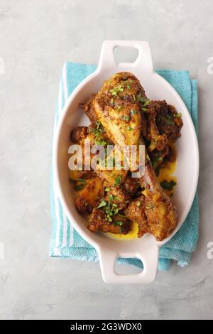 Chicken Tava fry or dry fry. A popular Indian Tawa Murg served in a white plate. Chicken masala garnished with coriander and spices. Copy space. Stock Photo