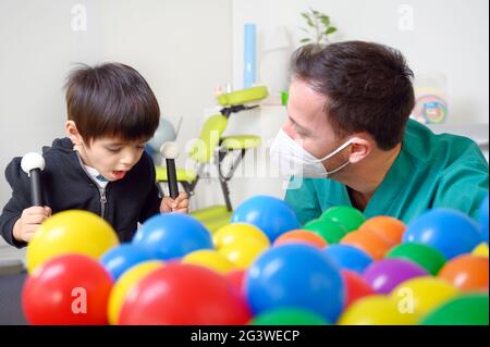 Physical therapist playing with children, with cerebral palsy Stock Photo