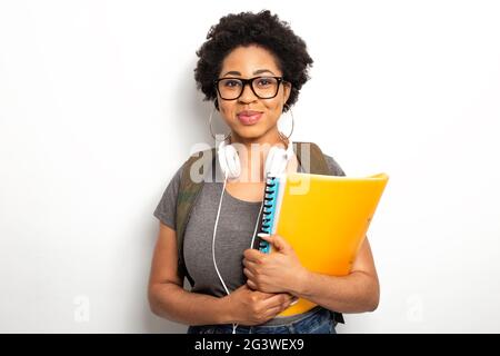 Portrait of a smiling African female student holding textbooks in her hands. Stock Photo