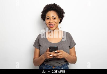 Portrait of a smiling African woman holding a phone. Stock Photo