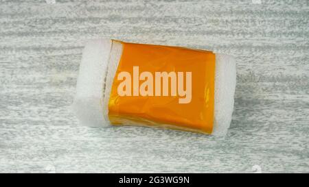 Plastic/polyetylene foam covered with orange adhesive tape - forming a package with lid Stock Photo