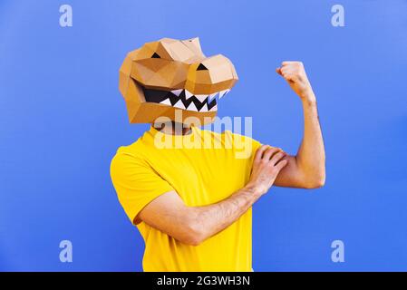 Cool man wearing 3d origami mask with stylish colored clothes - Creative concept for advertising, animal head mask doing funny things on colorful back Stock Photo
