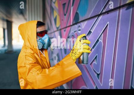 Street artist painting colorful graffiti on public wall - Modern art ...