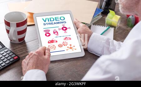 Video streaming concept shown on a tablet held by a man Stock Photo
