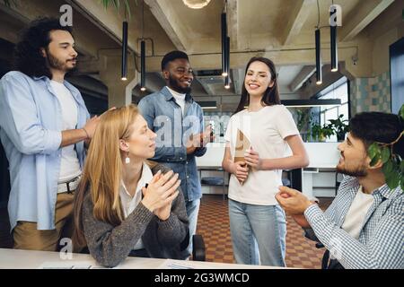Group of young business people applaud their female colleague after presentation Stock Photo