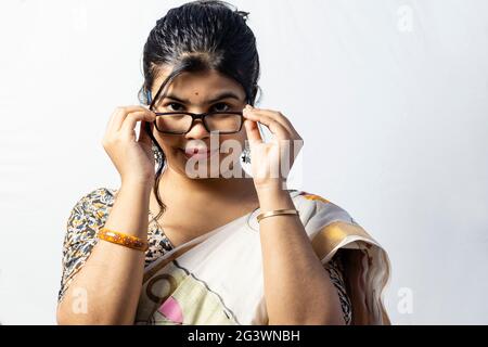 Isolated on white background an Indian woman in saree looks over the eyeglasses Stock Photo
