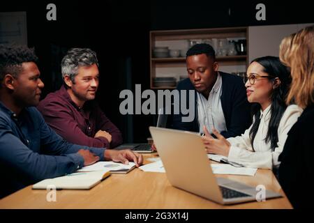 Group of diverse business executives in meeting around a table discussing new start up project Stock Photo