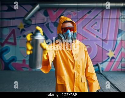 Graffiti artist pointing spray paint can to camera Stock Photo - Alamy
