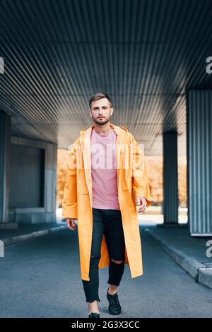 Fashionable trendy young man walking down the street looking at the camera Stock Photo