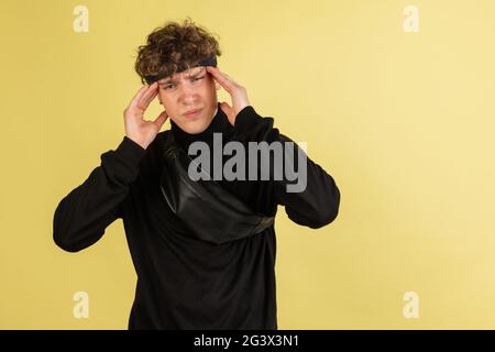 Stressed young man feel pain and having terrible strong headache concept. Tired upset black guy massaging temples and suffering from migraine Stock Photo