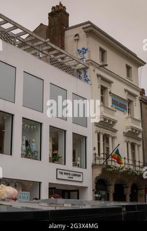 Graffiti written high up on a white wall above The Royal Arcade entrance in Norwich  City centre Stock Photo