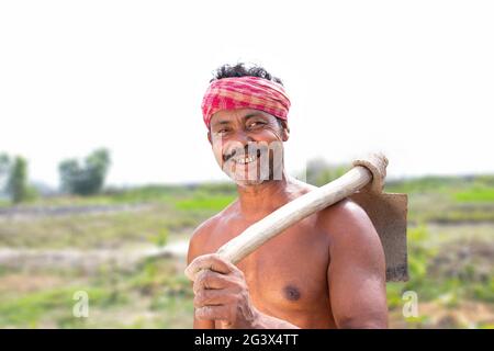 Portrait of a Farmer holding a Shovel in agricultural field Stock Photo