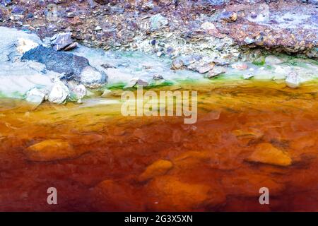 Close up of orange red river with iron ore and copper ore deposits in the Rio Tinto mining area Stock Photo