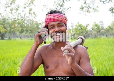Indian farmer talking on smart phone Stock Photo