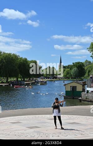 A Busker playing her violin by the banks of the River Avon in the Warwickshire town of Stratford upon Avon Stock Photo