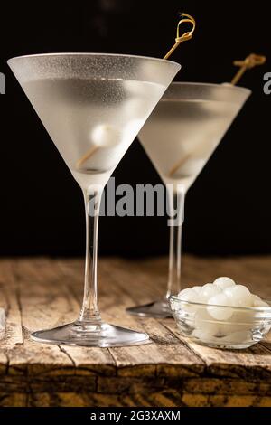 Gibson martini cocktail with onions on wooden table and black background Stock Photo
