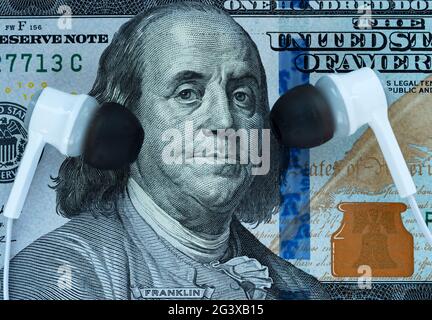 In this photo illustration earphones near Franklin's ears on a 100 dollar bill Stock Photo