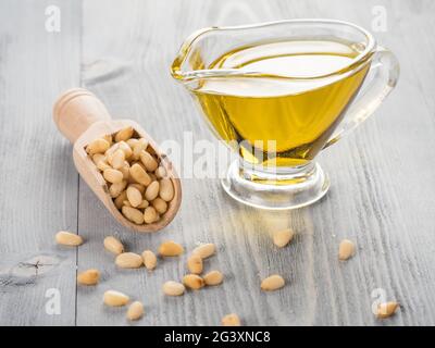 Pine nut oil and pine nuts on gray wooden background Stock Photo