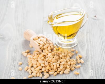 Pine nut oil and pine nuts on gray wooden background Stock Photo