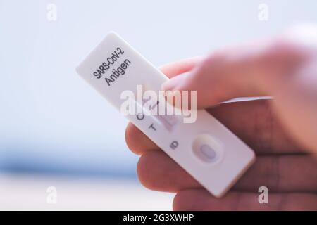 Express corona test at home: Close up of fingers holding a negative covid antigen test Stock Photo