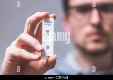 Express corona test at home: Close up of young man holding a negative covid antigen test Stock Photo