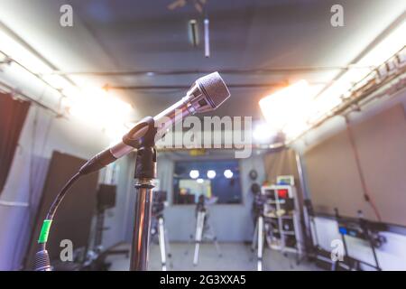 Microphone in recording studio, equipment and professional studio lighting in the blurry background Stock Photo