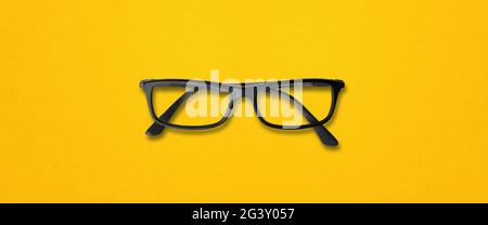 Black glasses isolated on yellow banner Stock Photo