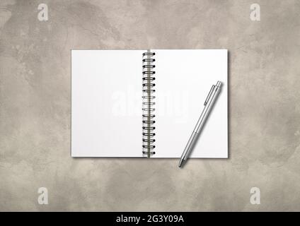 Blank open spiral notebook and pen isolated on concrete background Stock Photo