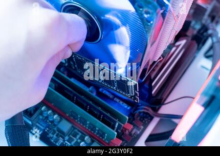 inserting plug in the ram ddr memory card in the computer mainboard, random access memory Stock Photo