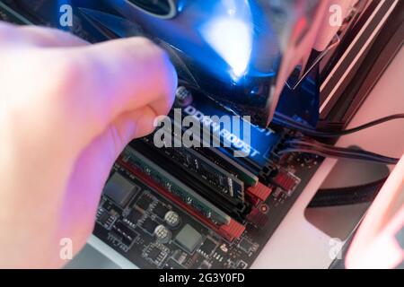inserting plug in the ram ddr memory card in the computer mainboard, random access memory Stock Photo