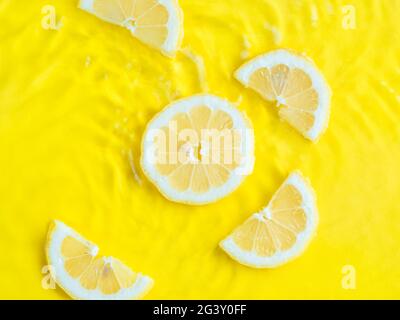 Intense yellow lemon citrus slice in water, texture summer background ...