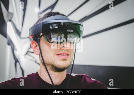 Young man wearing high end virtual reality glasses. Concept for VR, future, gadgets and technology. Stock Photo