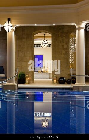 Evening shot of pool room with a view through open door to threatment rooms, Bath, United Kingdom Stock Photo