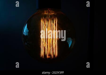 Close-up of a glowing incandescent light bulb filaments Stock Photo