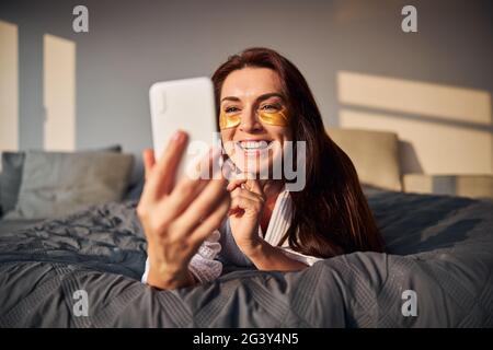 Amazing longhaired woman having online video conversation Stock Photo