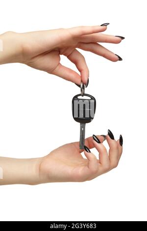 A female hand with a black nails manicure holds a black car key with her fingers. Isolated on white background. Stock Photo