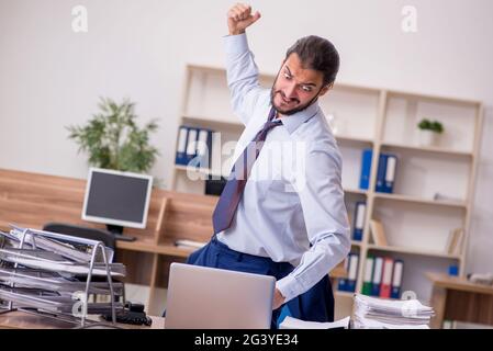 Young businessman employee unhappy with excessive work in the of Stock Photo