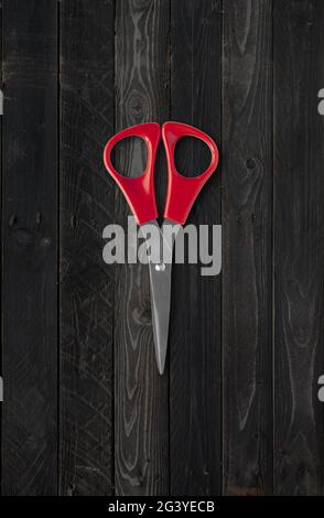 Pair of scissors isolated on black wood background Stock Photo