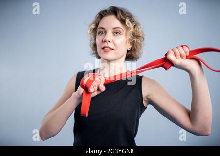 Sports woman exercising with a resistance band. Slim girl in good shape. People, sport and fitness concept. Exercise bands worki Stock Photo