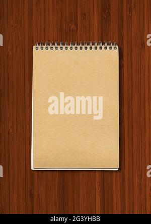 Spiral closed notebook mockup on dark wood background Stock Photo