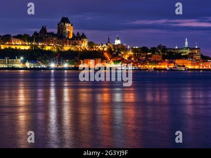 Evening lights of Quebec City and the Chateau Frontenac shine on the St Lawrence river, as seen from Lévis, Quebec, Canada Stock Photo