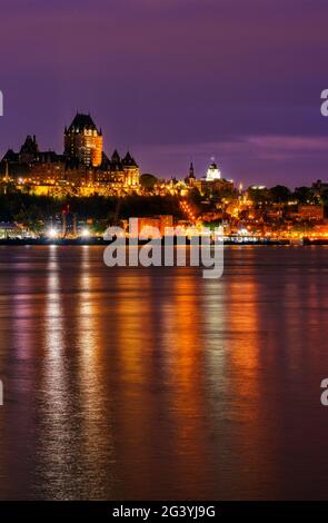 Evening lights of Quebec City and the Chateau Frontenac shine on the St Lawrence river, as seen from Lévis, Quebec, Canada Stock Photo