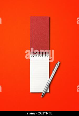 Blank open spiral notebook and pen isolated on red Stock Photo
